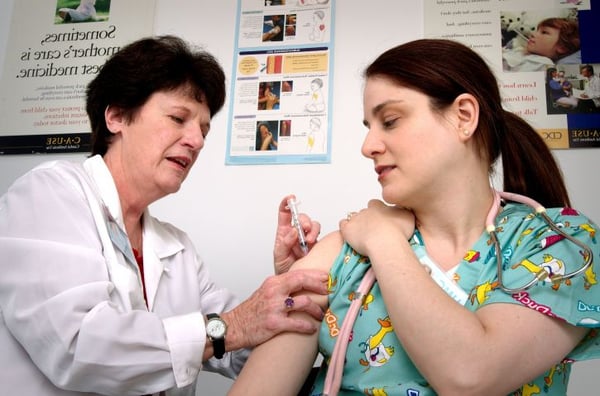 Nurse administering intramuscular vaccination
